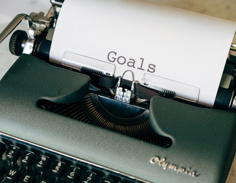 Schreibmaschine mit Papier, auf dem das Wort "Goals" geschrieben steht.